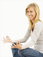 Woman smiling while meditating in a cross-legged position