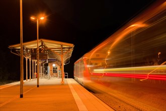 Railway station at night with moving train