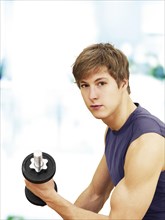 Young man doing strength training with a dumbbell