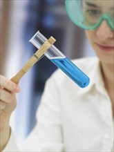 Scientist wearing a protective mask and holding a test tube