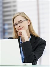 Businesswoman wearing glasses and using a laptop