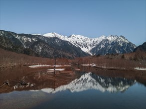 Snow-covered Japanese Alps reflected in Lake Taisho Pond