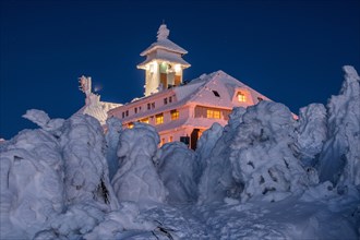 Snow-covered Fichtelberghaus in the evening in winter on the Fichtelberg mountain
