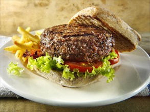Beef burger in a wholemeal bun with chips