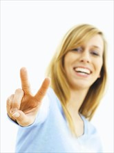 Young woman making a V for victory sign