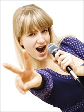 Young woman singing into a microphone
