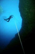 Freediver descending to a cave