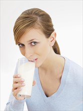 Young woman drinking from a glass of milk