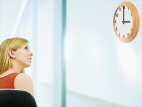 Young woman looking at a clock