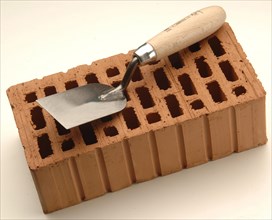Smoothing trowel on a red brick