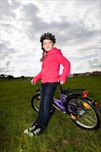 Girl with a cycling helmet and a bike