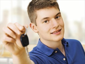 Teenager holding car keys after passing a driving test