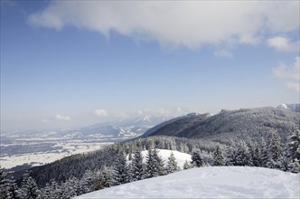 View from the peak of Mt Schwarzenberg to a snow-covered on snow-covered alpine upland and the Chiemgau Alps