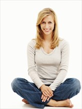 Woman smiling while sitting in a cross-legged position