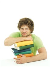 Young male student with a stack of books