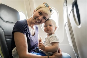 Mother with baby playing in a passenger airplane