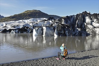 Hiker takes pictures of the glacier Solheimajokull