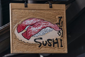 Signboard with inscription Sushi in front of a restaurant