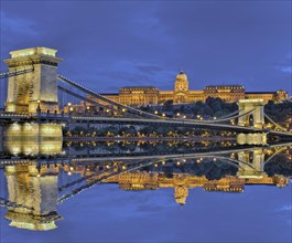 Chain bridge in front of castle palace with reflection in the Danube
