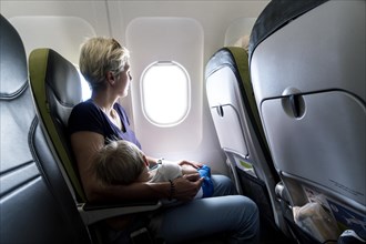 Mother with sleeping baby in a passenger airplane