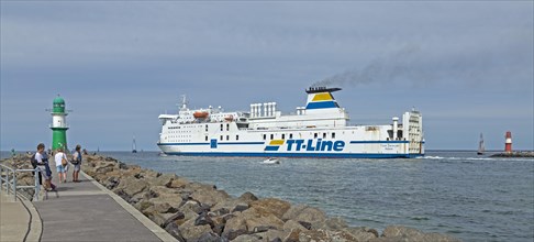 Baltic Sea ferry passes pier light at the entrance to Unterwarnow