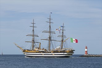 Italian sailing training ship Amerigo Vespucci passes pier lights at the entrance to the Unterwarnow