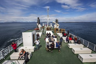 Tourists sitting on the deck of the ferry Baldur between Brjanslaekur and Stykkisholmur