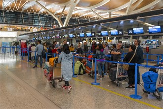 Travellers wait at the counter at the check in