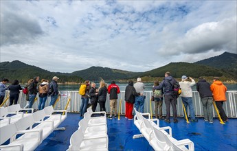 Passengers on deck of a ferry in the fjord