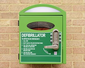 Automated external defibrillator mounted on the wall of a village hall