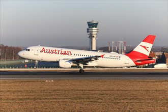 Austrian Airlines airplane landing at the Brussels Airport by the control tower Skeyes