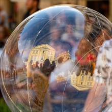 Reflection of old houses in soap bubble