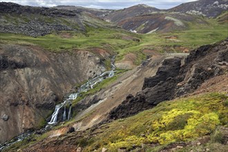 Volcanic landscape and waterfall on the hiking trail to Reykjadalur
