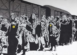 Column of Jews with a Jewish star in front of a freight car
