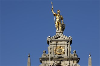 Golden figure with lance on gable of a guild house