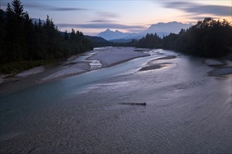 View from a bridge after sunset to the wide Isar riverbed with the Wetterstein range in the background