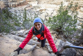 Young woman climbing ladder