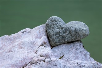 Stone in the shape of a heart lies in the notch of another stone