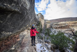 Young woman Trail descending into the canyon to Sipapu Bridge