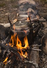 Large sooty coffee kettle on campfire