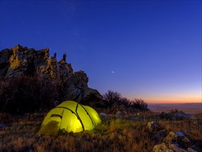 Tent under a rock at dusk
