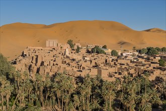 Overlook over the oasis of Taghit with sand dunes