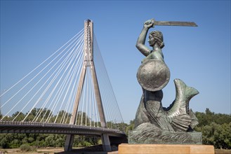 Bronze sculpture of the Warsaw mermaid on the bank of the Vistula River
