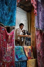 Indian Man sewing blankets