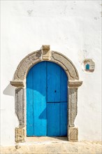 White house wall with blue wooden door