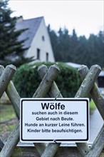 Sign on fence warns of wolves