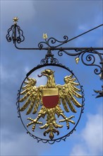 Hanging shop sign with golden eagle