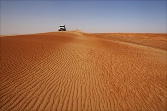 Off-road vehicle and tourist on a sand dunes