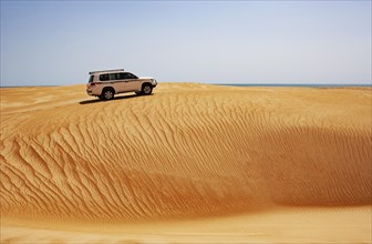 Off-road vehicle drives on sand dune
