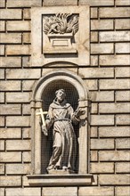 Statue of St. Francis of Assisi in a niche on the facade of the Church of the Knights of the Cross
